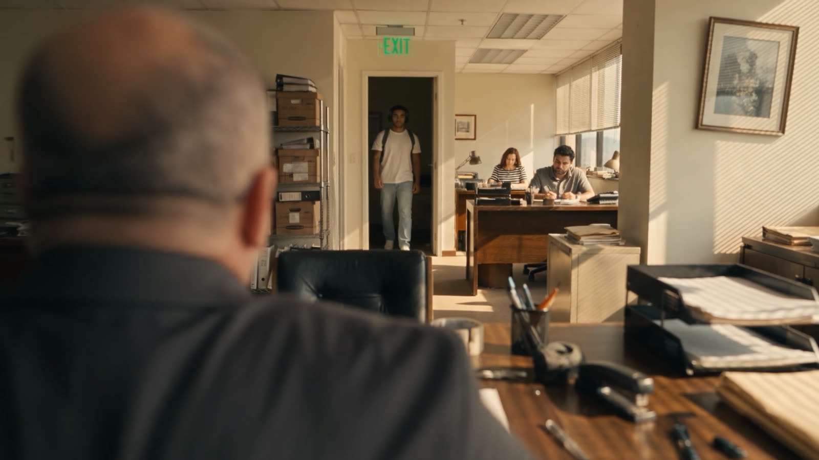 Arriving at the office, the boss in the foreground with his back turned
