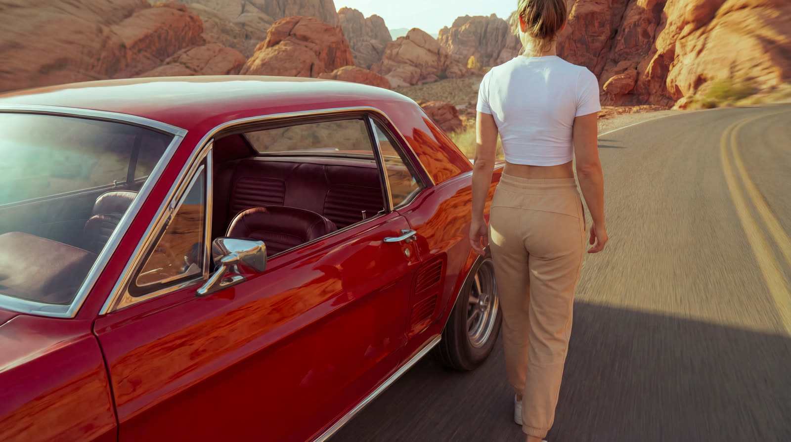 A woman walking to the back of the Mustang