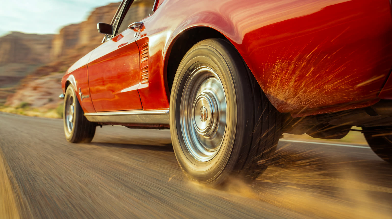 Detail of the rear wheel sliding and kicking up dust