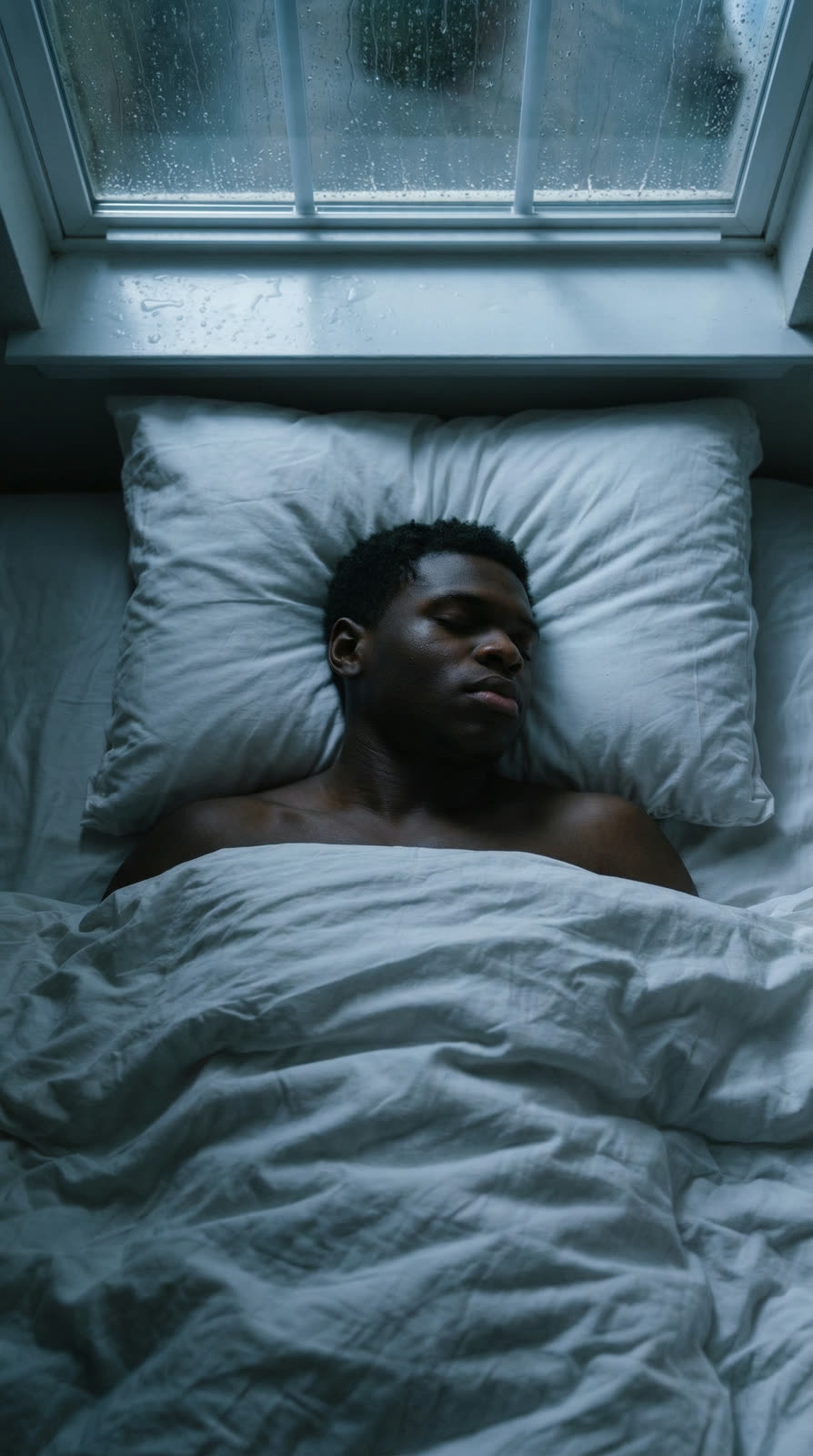 The athlete lying in bed, seen from above, awake