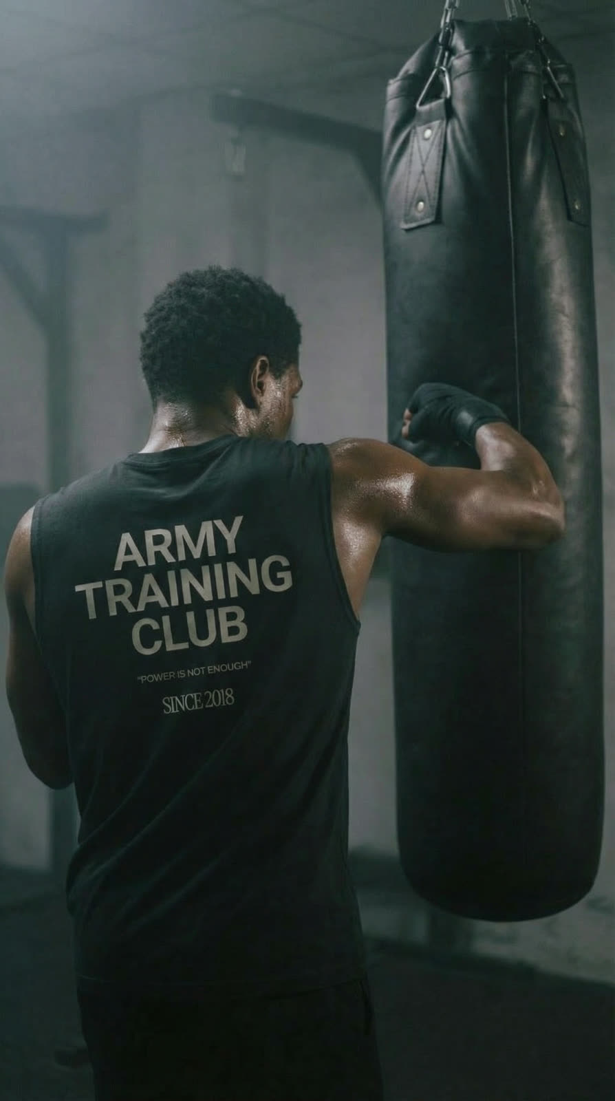 The athlete from behind, Army Training Club shirt, working the heavy bag